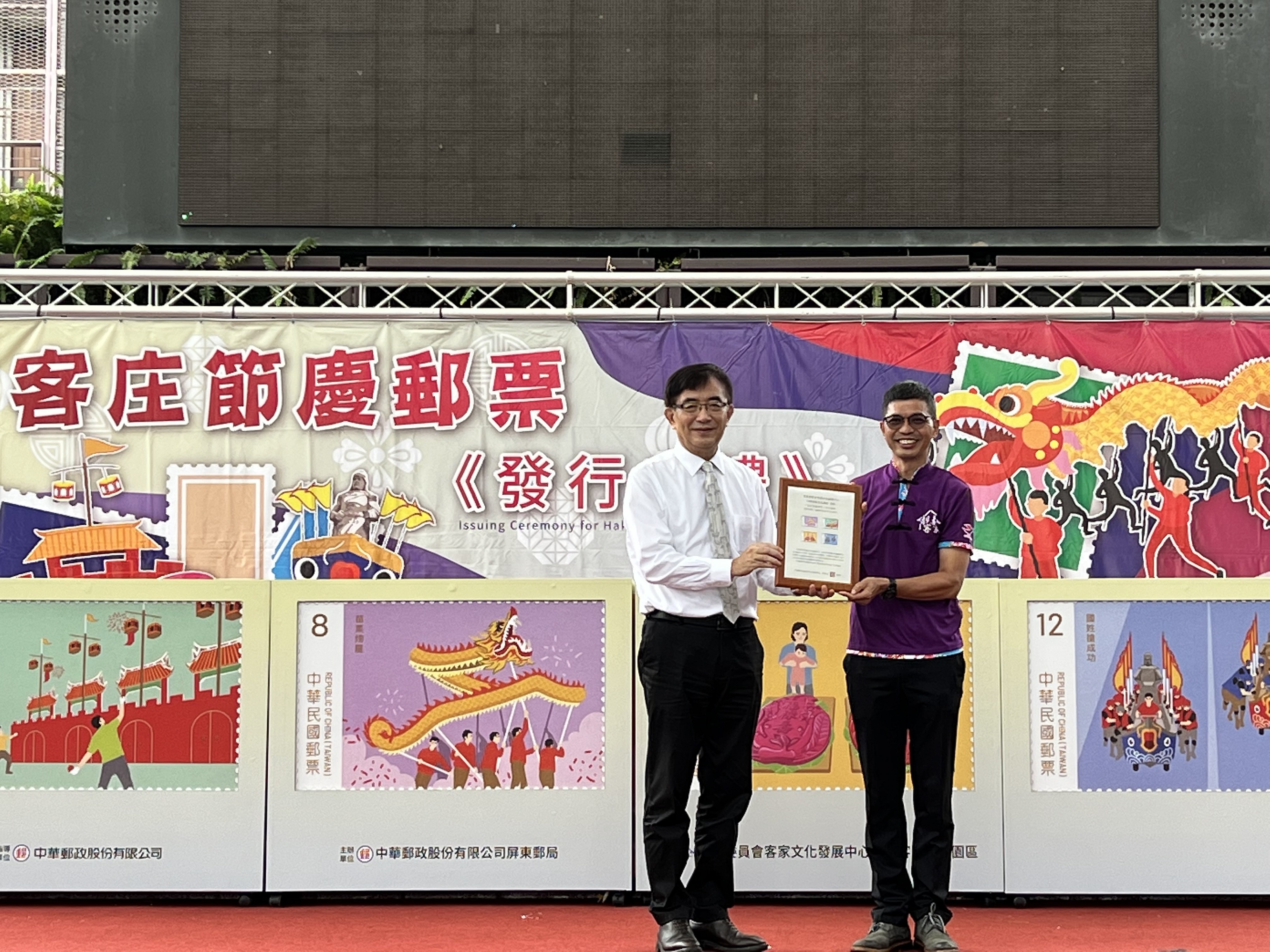 中華郵政公司吳宏謀董事長致贈郵票紀念框予客家委員會客家文化發展中心何金樑主任。